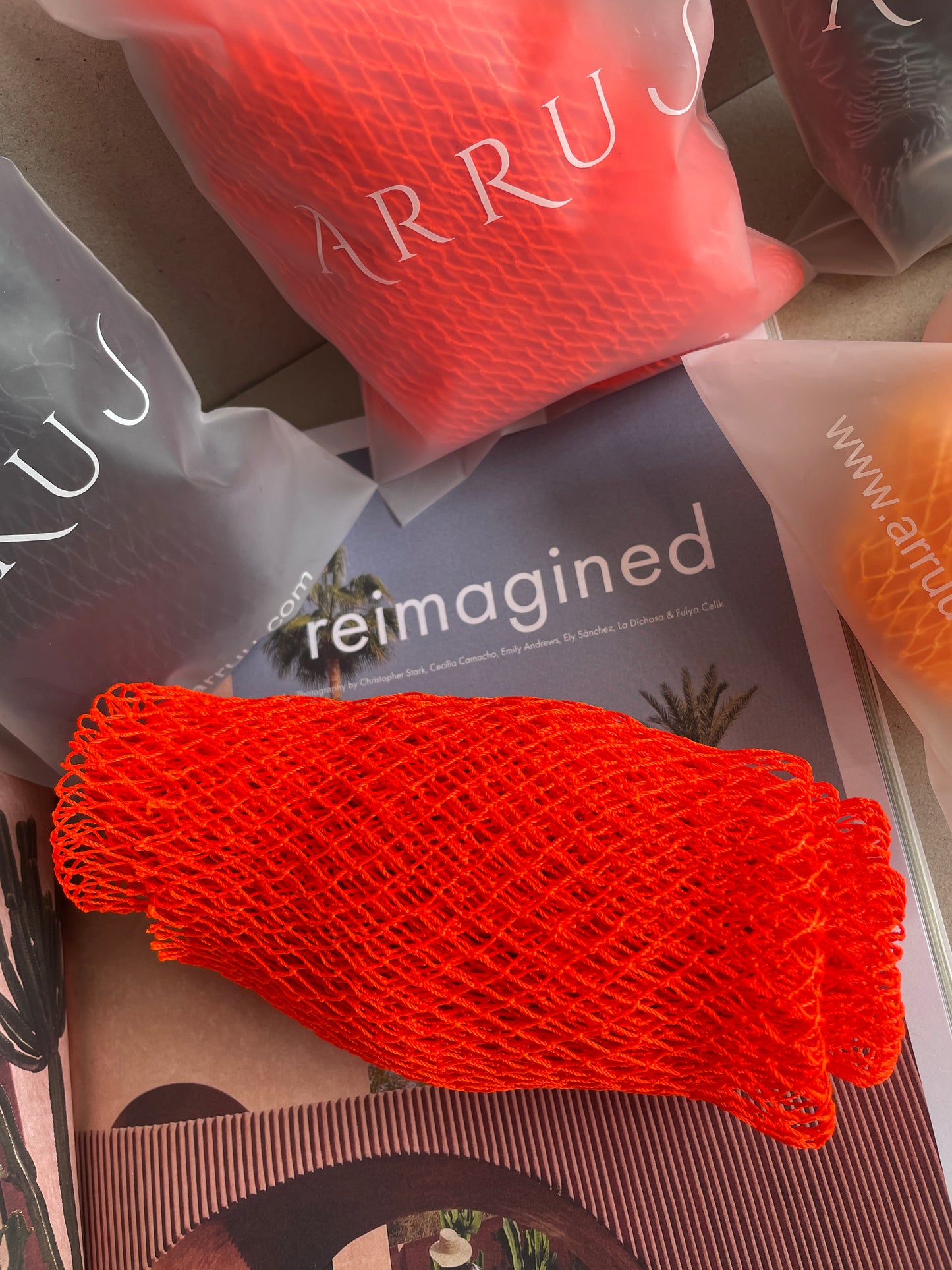 Orange African net sponge on a magazine. African bath sponge, Sapo net sponge, African exfoliating net, handmade bath sponge, long exfoliating sponge, deep cleansing bath net, African shower net, full body exfoliator, loofah alternative, traditional African sponge